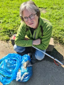 Councillor Jonathan Elmer next to rubbish collected from flooded land next to river Browney